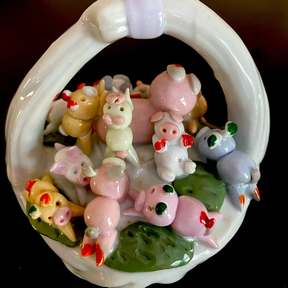 Whimsical ceramic pigs in a basket